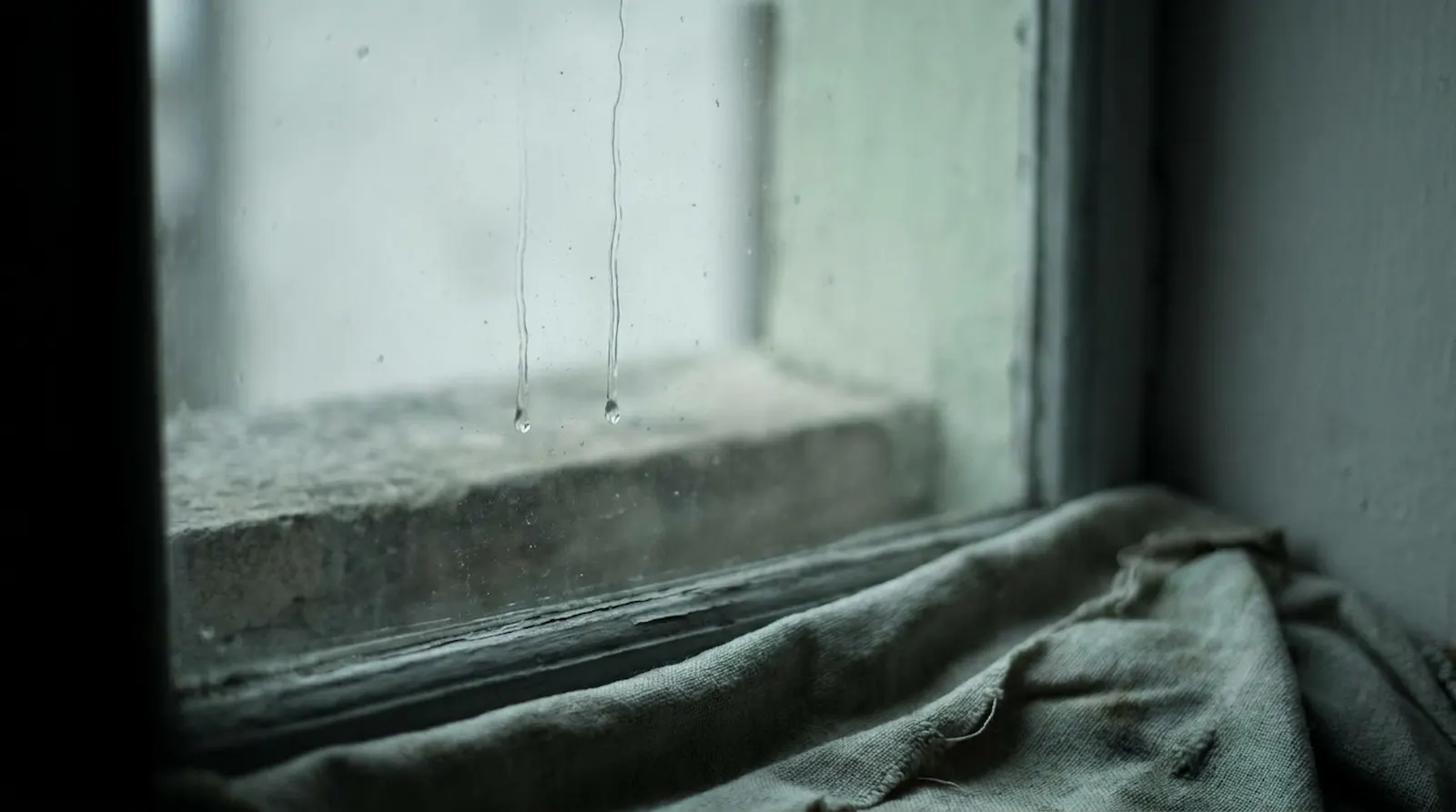 Keine Energie für Nähe – zwei Regentropfen laufen parallel am Fensterglas herunter ohne sich zu berühren